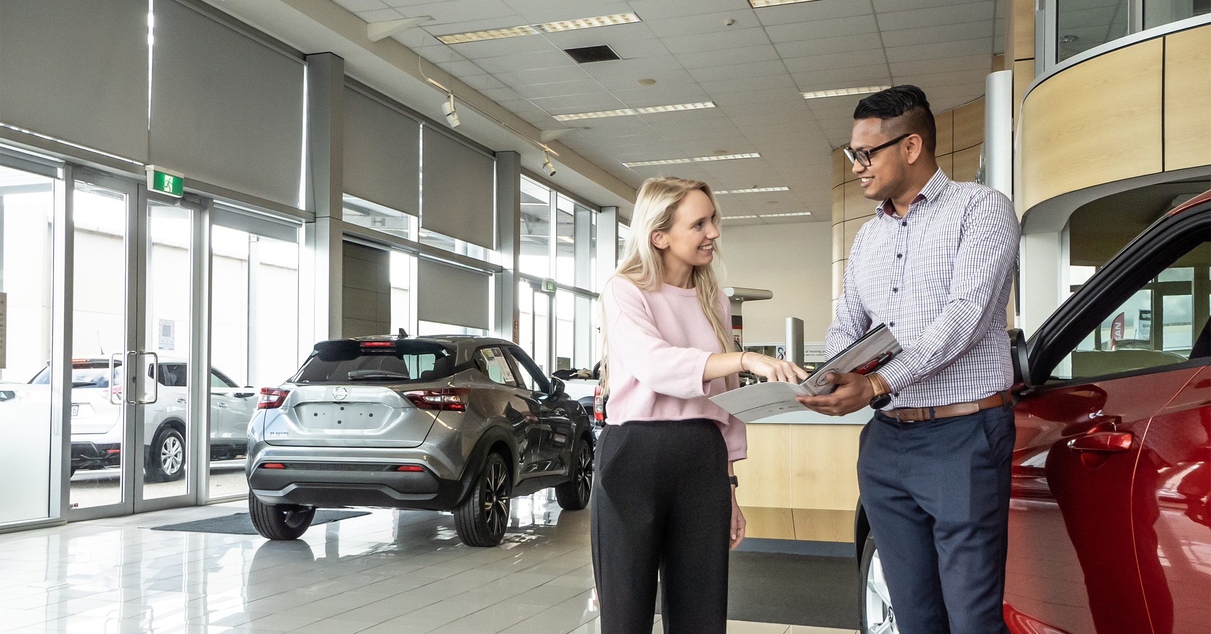 male and female buying a Nissan looking very happy